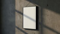 Blank white poster frame hanging on concrete wall with dramatic shadow patterns from window light creating minimalist interior design mockup space.