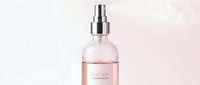 Rose facial mist spray bottle with chrome atomizer on soft pink background, isolated for cosmetics and skincare product design use.
