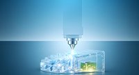 Precision laser or CNC cutting tool engraving transparent acrylic block with glowing green circuit pattern, industrial manufacturing and technology concept.