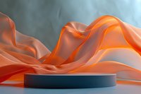 Abstract orange flowing fabric waves with dark blue cylindrical podium for product display and presentation on soft gradient background.