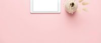 Tablet with blank screen and dried flowers on pink background, flat lay workspace for web design and digital marketing projects.