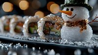 Creative sushi presentation with decorative mini snowman made of rice alongside California rolls on black plate with festive bokeh lights in background.