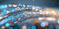 Magical glowing curve with blue and gold bokeh lights on dark background, sparkling particles create dreamy atmospheric effect. Abstract festive backdrop.