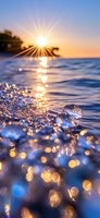 Sunlight sparkles on ocean waves creating magical bokeh effect with water drops and golden reflections at sunset, waves splashing against shore in blue hour.