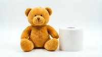 Adorable brown teddy bear sitting next to white tissue box on clean background, perfect for childcare, hygiene products, and comfort concepts.
