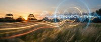 Digital connectivity concept with glowing network lines over rural landscape at golden hour sunset showcasing modern technology integration in nature.