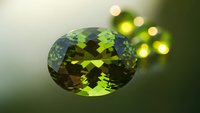 Stunning green gemstone with brilliant faceted cut displaying rich emerald tones and exceptional clarity against soft bokeh background for luxury jewelry design.