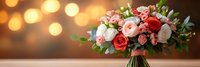 Elegant bridal bouquet with pink and red roses, white flowers and greenery against warm bokeh lights background for wedding celebrations.