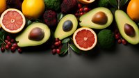 Fresh avocados, grapefruit halves, broccoli and red berries arranged on dark background, top view composition for healthy eating and nutrition concept.