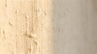 Beige knitted wool fabric texture with cable pattern detail, cozy winter sweater material background for fashion and textile design projects.
