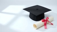 Black graduation cap with diploma scroll tied with pink ribbon on white background symbolizing academic achievement and educational success.