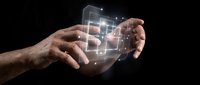 Hands holding glowing digital interface with connected icons and data visualization on black background, representing technology, innovation, and mobile app development.