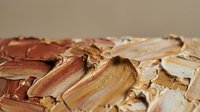 Thick textured oil paint strokes in warm brown and beige tones creating abstract artistic surface for creative projects and modern interior design.