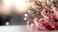 Pink frosted Christmas tree branch with warm bokeh lights creating festive holiday atmosphere for seasonal decorations and winter celebrations.