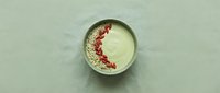 Laboratory petri dish containing bacterial culture with red colonies growing on agar medium for microbiology research and scientific analysis.