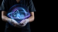 Medical professional holding glowing digital stethoscope hologram representing modern healthcare technology and telemedicine innovation on dark background.