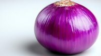 Fresh purple red onion close up on white background with selective focus, vibrant color and natural texture detail for food and cooking concepts.