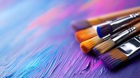 Colorful paint brushes on vibrant blue and purple textured background with artistic strokes, creating dynamic composition for creative and artistic projects.