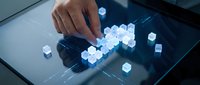 Hand touching glowing blue cube blocks on digital tablet screen, representing data processing, blockchain technology, and futuristic computing solutions.