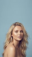 Young blonde Caucasian woman with wavy hair and natural makeup on blue background for beauty and skincare advertising campaigns.