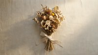 Dried wildflower bouquet tied with a ribbon on a linen background, featuring warm neutral tones for rustic, boho, and farmhouse decor.