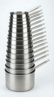 Stack of stainless steel saucepans with long handles arranged in graduated sizes on white background for professional kitchen cookware display.