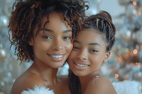 Two young African American women with natural curly hair embracing and smiling warmly together in soft golden light creating intimate friendship moment.