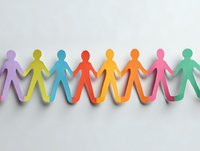 Colorful paper cutout figures holding hands in a row symbolizing unity, diversity, and teamwork on white background.