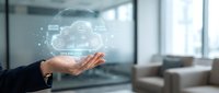 Businessman holding holographic cloud computing network with data analytics icons floating above palm in modern office environment for digital transformation.