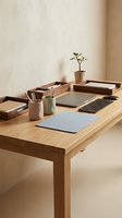 Modern minimalist home office workspace with wooden desk, laptop, organizers and plant for productivity and remote work setup.