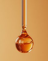 Golden honey dripping from glass dropper with bubbles against warm beige background for natural skincare and wellness products.