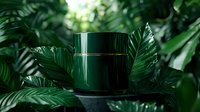 Dark green cosmetic jar surrounded by lush tropical leaves creating luxurious natural skincare composition against blurred botanical background.