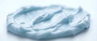 Whipped light blue cream or frosting swirl isolated on white background, ready for design projects, bakery graphics, and culinary applications.