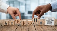 Building inclusive teams diversity equity inclusion concept with hands placing wooden blocks featuring accessibility symbols on desk.