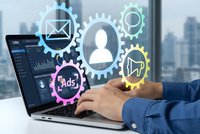 Business professional managing digital marketing automation with colorful gear icons representing customer data analytics and advertising workflows.