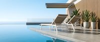 Modern luxury poolside terrace with infinity pool, contemporary lounge chairs and tropical plants overlooking ocean horizon for resort hospitality design.