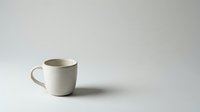 Minimalist white ceramic coffee mug on clean neutral background for modern kitchen design and branding mockups.