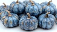 Decorative blue pumpkins with copper stems and metallic gold speckles arranged in group on white background, seasonal autumn harvest decor for Halloween and fall.