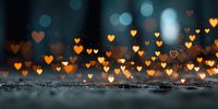 Glowing golden heart bokeh lights on dark background, creating romantic atmosphere for Valentine's Day cards, wedding invitations, or love-themed designs.