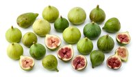 Fresh green and red figs arranged on white background, whole and halved fruits showing pink and red flesh interior, suitable for food photography, culinary design, recipe blogs, and healthy eating content.