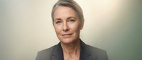 Professional mature Caucasian businesswoman in dark suit with confident expression and blonde hair for corporate leadership and executive concepts.