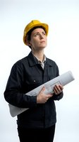Male construction worker wearing yellow hard hat and dark work jacket, holding rolled blueprints while looking upward, isolated on white background for professional and industrial design projects.