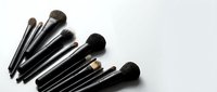 Set of professional makeup brushes with black handles arranged on white background, copy space for beauty and cosmetic design.