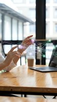 Hands interacting with holographic network connections above laptop in modern office workspace showcasing digital transformation and connectivity concepts.