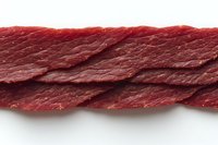 Raw beef meat strip isolated on white background, showing fresh red muscle fiber texture and marbling detail, suitable for food industry and culinary design.