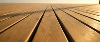 Wooden deck planks perspective view with natural wood grain texture and warm lighting creating depth and vanishing point for construction projects.