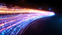 Glowing light trails curve across dark background with vibrant blue and orange streaks creating dynamic motion effect, suitable for technology and innovation concepts.