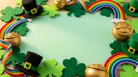 St. Patrick's Day themed flat lay with shamrocks, gold coins, rainbow ribbons and leprechaun hats on mint background. Perfect for holiday marketing and seasonal design projects.
