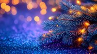 Christmas tree branches with warm golden lights on blue bokeh background creating festive holiday atmosphere for seasonal decorations and celebrations.