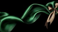 Elegant emerald green silk ribbon with beige satin bow flowing gracefully against dark background creates luxurious festive mood for holiday designs and celebrations.